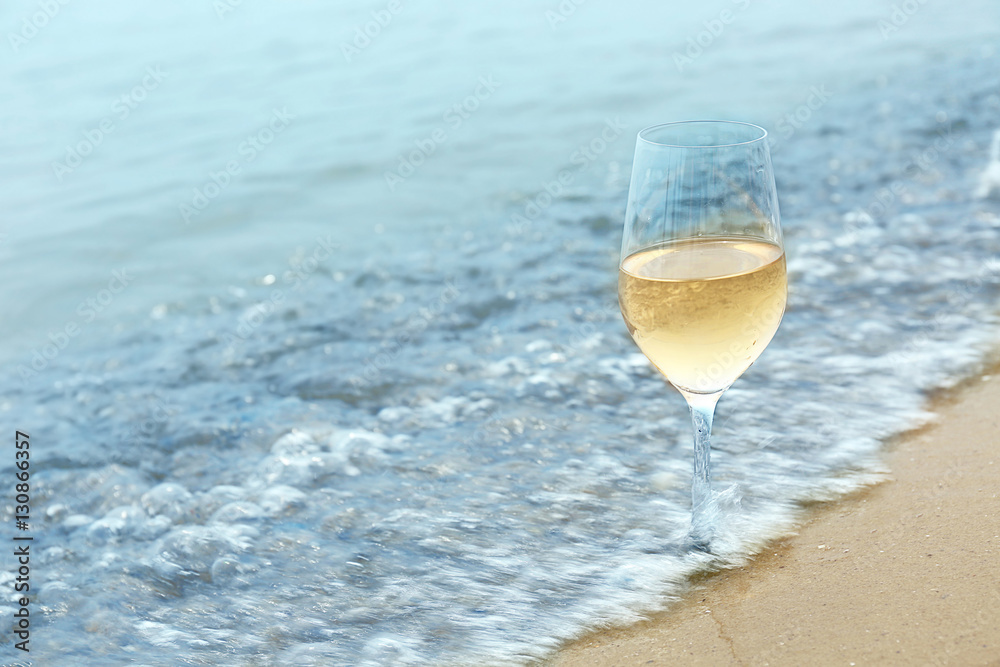 Glass of wine on sea shore, closeup Glass of wine on sea shore, closeup
