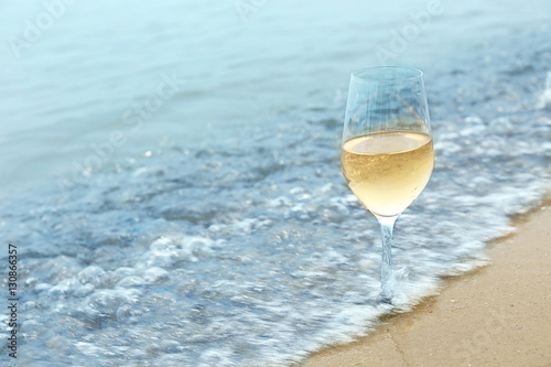 Glass of wine on sea shore  closeup