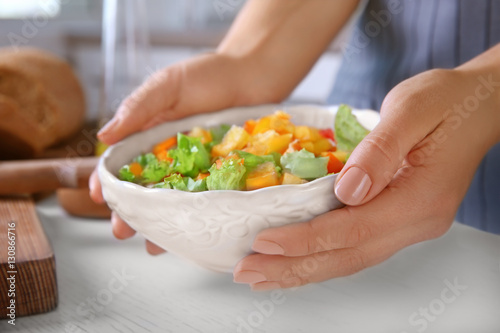 Woman holding fresh vegetable salad