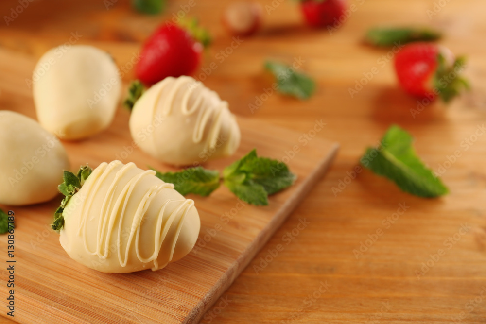 Delicious strawberries with chocolate and mint on wooden board