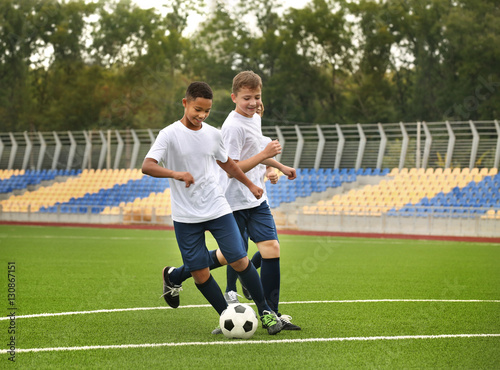 Boys playing football at stadium © Africa Studio