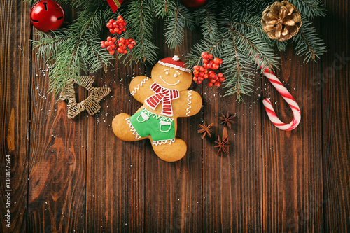 Composition of tasty gingerbread cookie and Christmas decor on wooden background photo