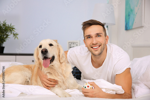 Handsome man lying with Lab...