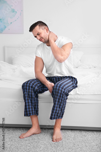 Handsome man feeling neck p...