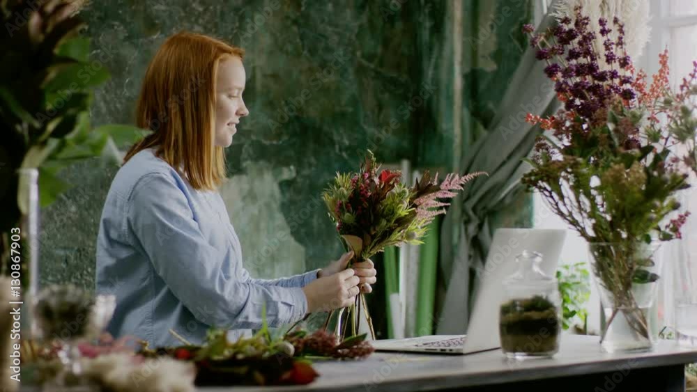 smiling florist arranging bunch of flowers near computer smiling florist arranging bunch of flowers near computer