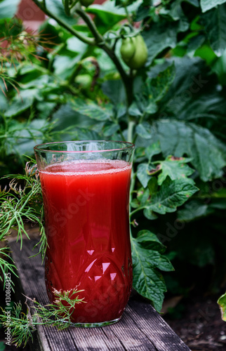glass of tomato juice, tomatoes and leaves
