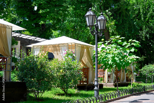 street cafe interior in green city park, ornate with flowers, summer season, bright sunny day photo