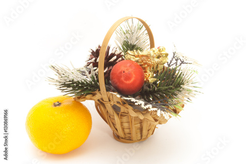 Christmas basket and one ripe tangerine isolated on white background
