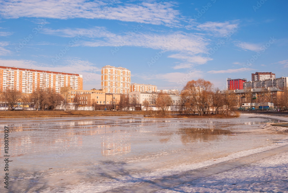 Frozen pond in the park of the modern city