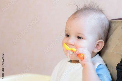 baby holding a spoon in his mouth