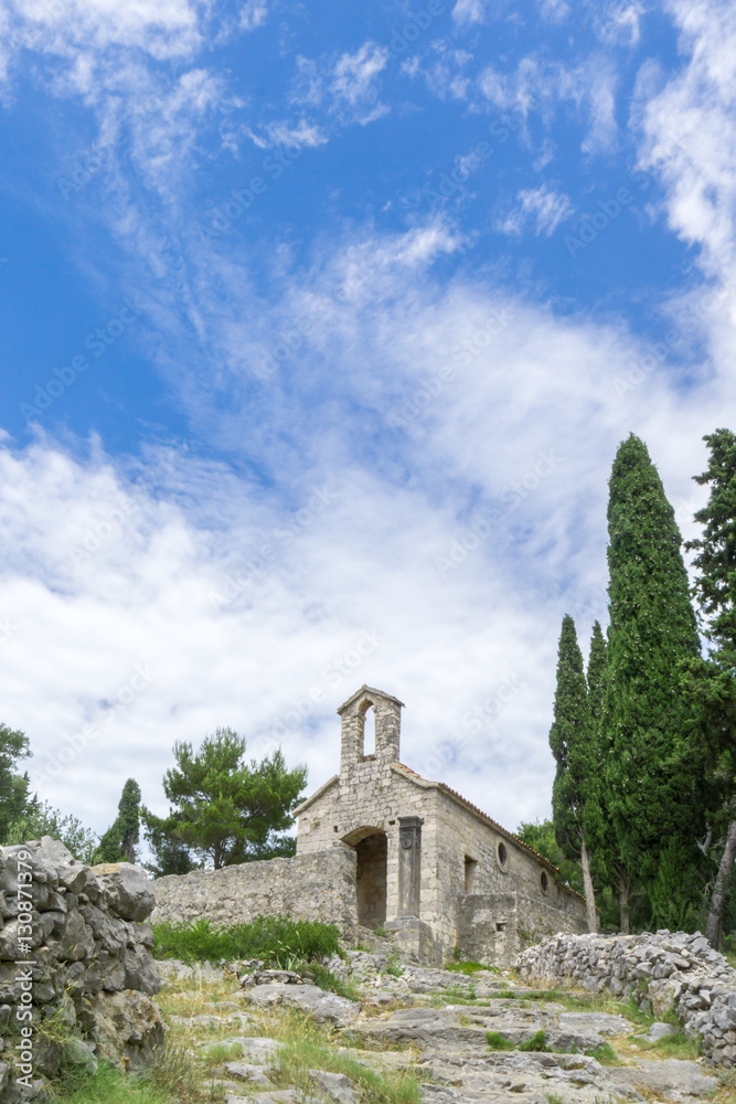 A small chapel that sits above Hvar Town along the steep path to the historic Spanish Fortress, image in a vertical orientation.