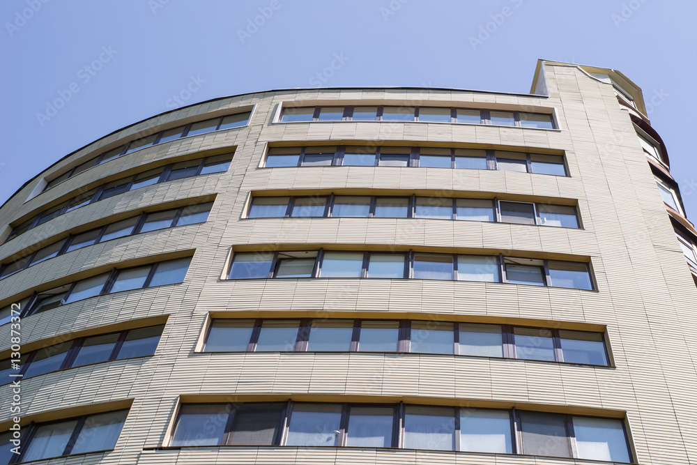 Office building exterior from bottom next to clean blue sky Office building exterior from bottom next to clean blue sky