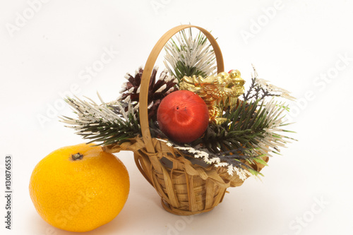 Christmas basket and one ripe tangerine isolated on white background
