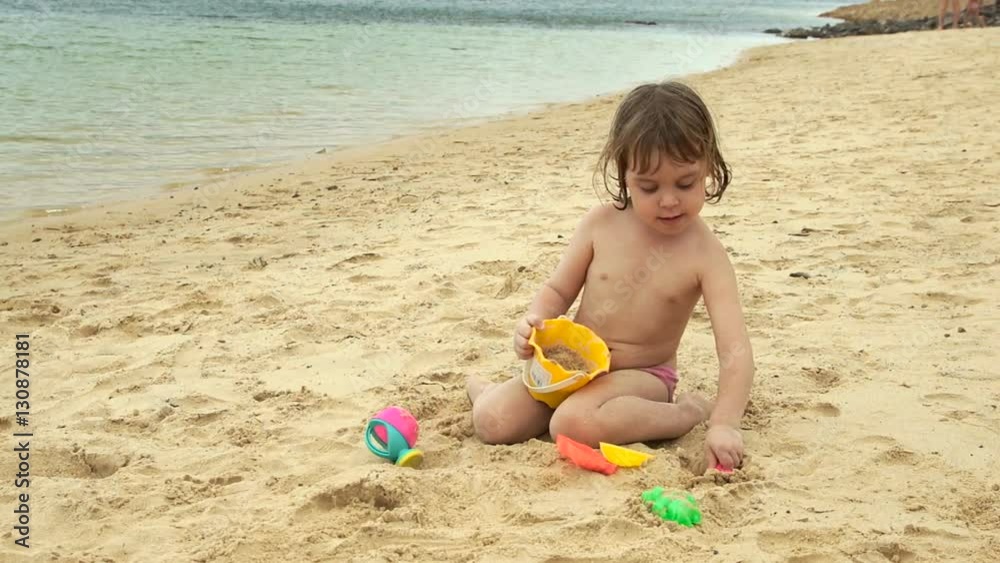 Adorable cheerful baby playing on the beach. The family got out on holiday to the sea. Adorable cheerful baby playing on the beach. The family got out on holiday to the sea.