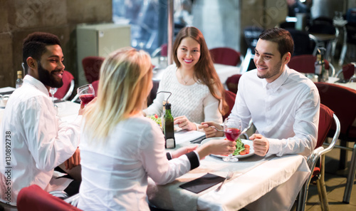 Two happy couples sitting at outdoor restaurant