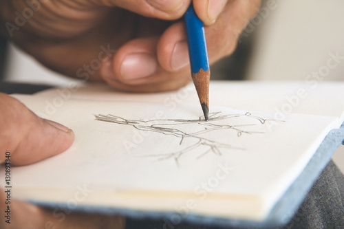 man writing a tree on sketchbook,Environment Conservative concept
