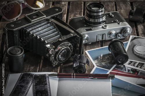 Retro Fotokameras auf einem Tisch / Alte Retro Fotoapparate auf einem Tisch mit Fotografien, Negativen und Filme mit Textfreiraum.