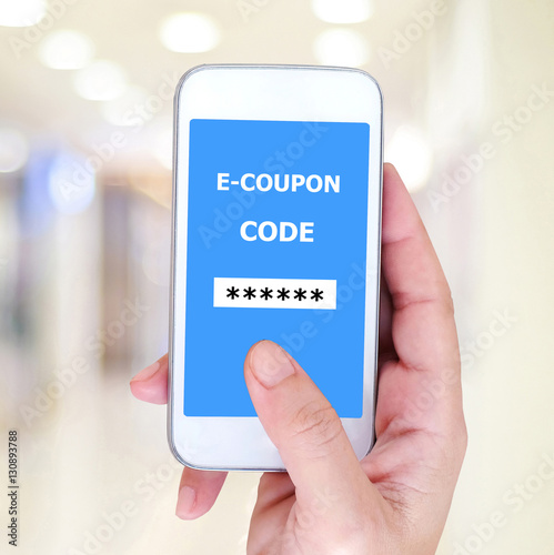 Hand holding smart phone with discount couopns code on screen