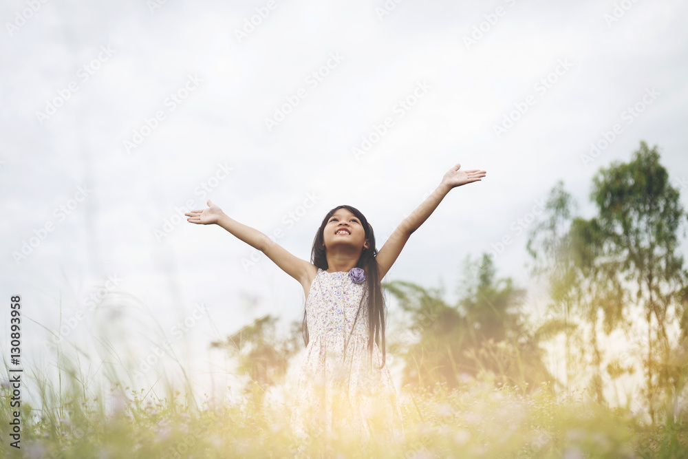 Cute Asian Girl raised hand at meadow happily. Cute Asian Girl raised hand at meadow happily.