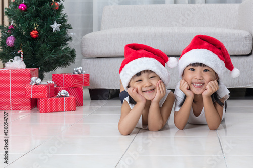 Happy Asian Chinese little sisters celebrate Christmas holiday a
