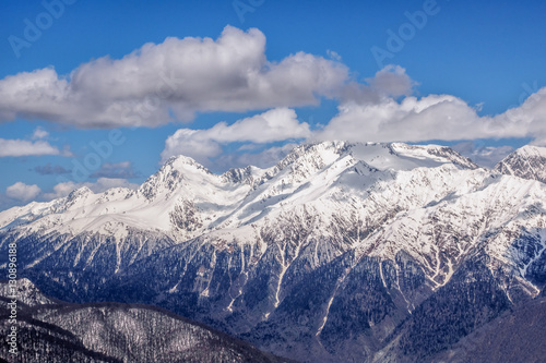Beautiful snowy mountain peaks and blue sky with clouds scenic winter landscape of the Main Caucasus ridge © Wilding