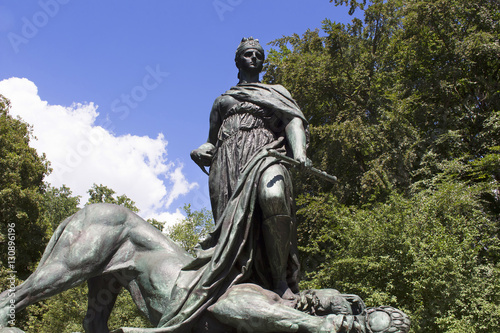 Woman stepping on lion sculpture at  Statue of Otto von Bismarck  in Tiergarten in Berlin. He was a conservative Prussian statesman who dominated German and European affairs from the 1860s until 1890.