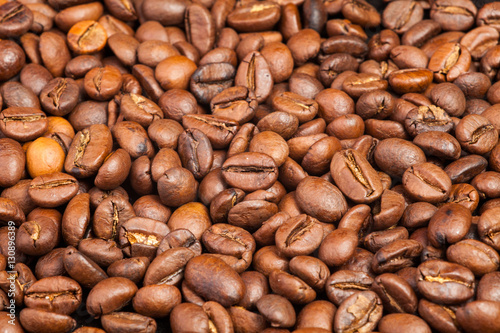 Many macro coffe beans on background.