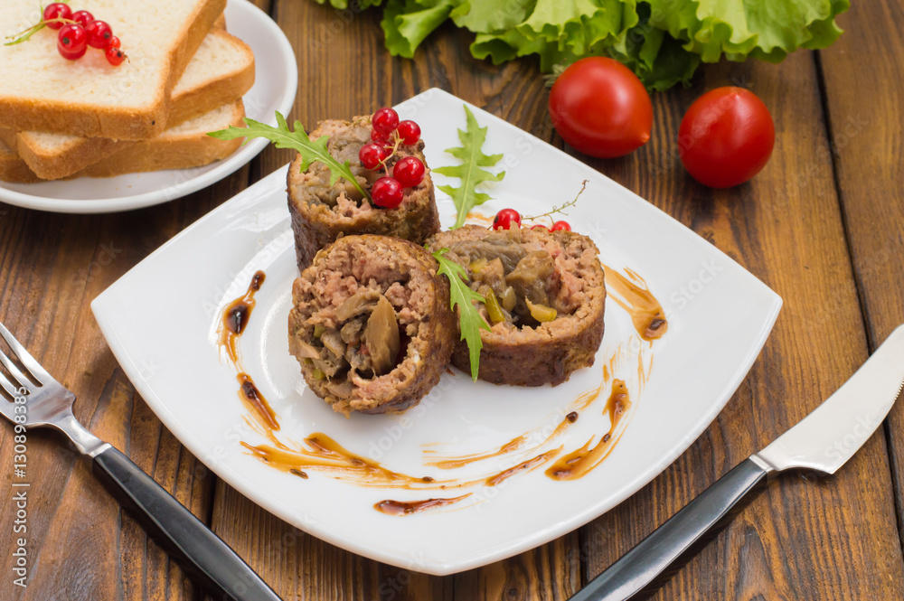 Meatloaf stuffed with mushrooms sauce and berries. Wooden rustic background. Close-up Meatloaf stuffed with mushrooms sauce and berries. Wooden rustic background. Close-up