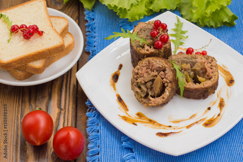 Meatloaf stuffed with mushrooms  sauce and berries. Wooden rustic background. Close-up
