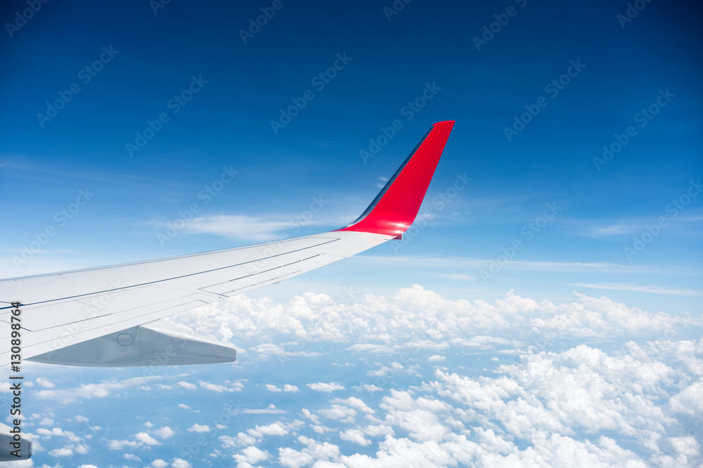 Naklejka premium airplane wing above the clouds