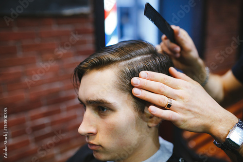 Master cuts hair of men in the barbershop