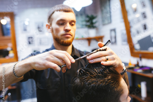 Master cuts hair of men in the barbershop