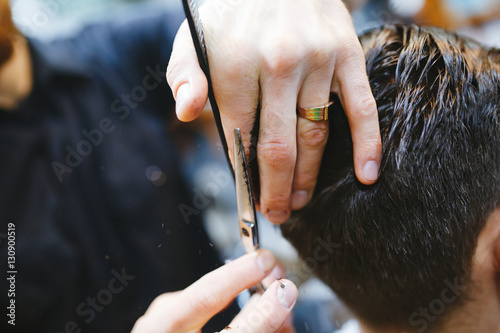Master cuts hair of men in the barbershop