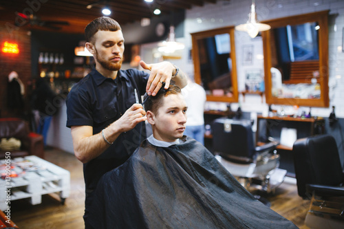 Master cuts hair of men in the barbershop