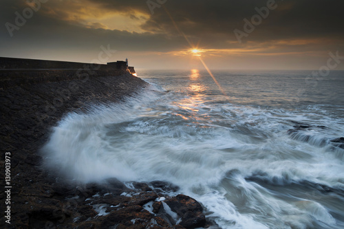 Sunrise and a choppy sea at Porthcawl lighthouse in South Glamorgan, South Wales