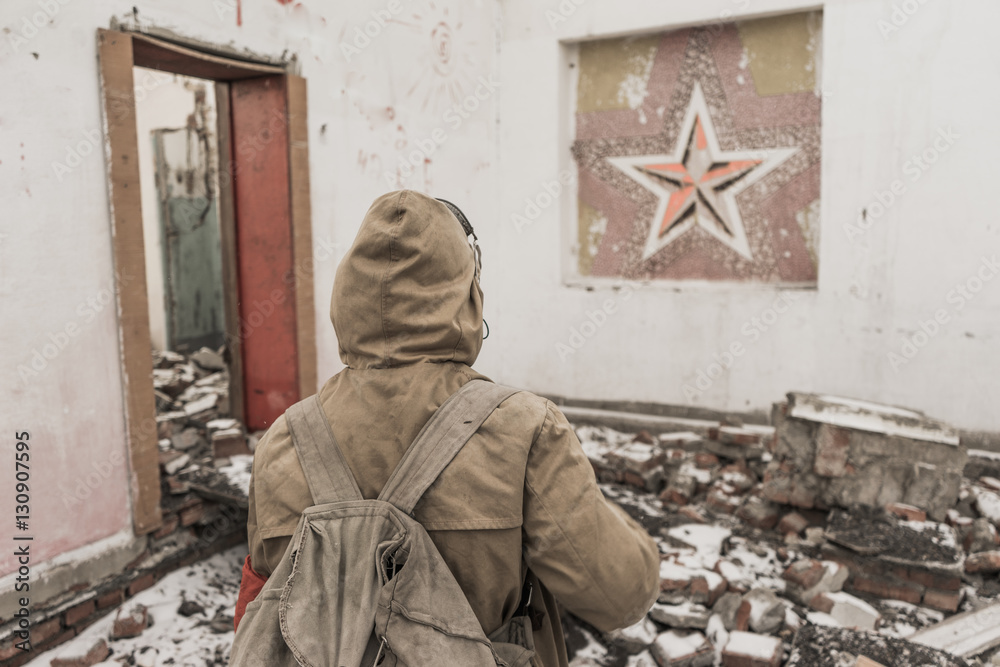 Fototapeta premium young boy stands near the destroyed building