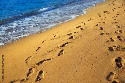 Sand beach. Scenic seacoast. Human footprints on the sand. Natural scenery