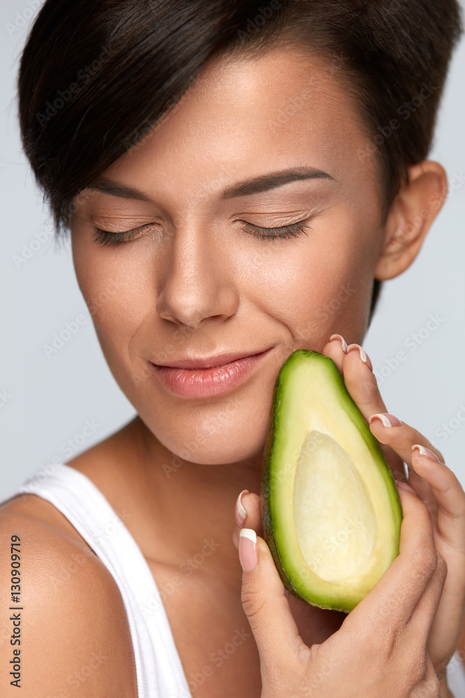 Skin Care And Beauty. Beautiful Woman Holding Avocado Near Face Skin Care And Beauty. Beautiful Woman Holding Avocado Near Face