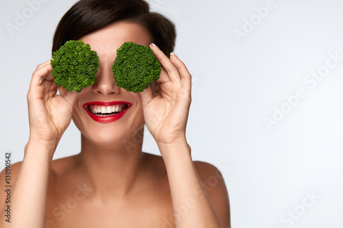 Food For Health. Beautiful Woman Holding Broccoli Before Eyes