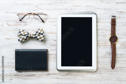 Gentleman kit of tablet watch glasses bow tie and notebook on wooden table