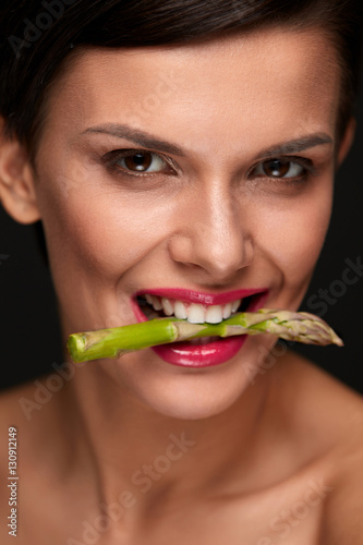 Healthy Eating. Beautiful Woman Holding Asparagus Between Teeth