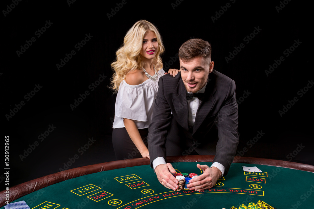 View of young, confident, man with the lady while he's playing poker game. View of young, confident, man with the lady while he's playing poker game.