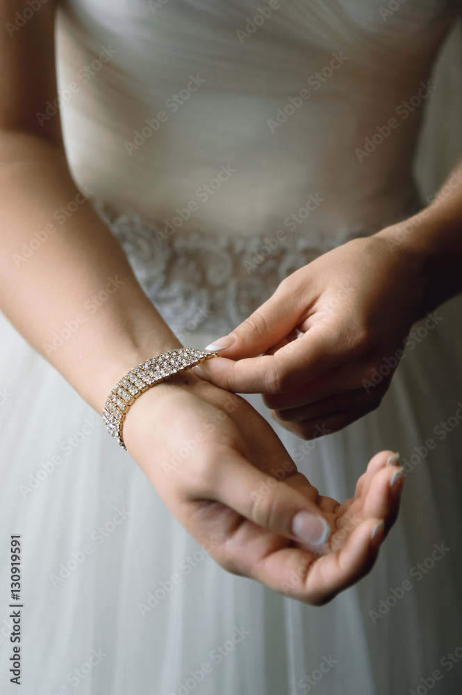 Bride puts on a bracelet, close-up