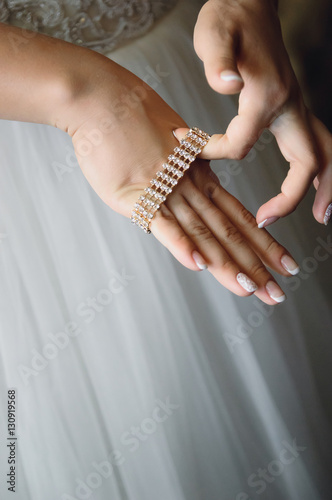 Bride puts on a bracelet, close-up