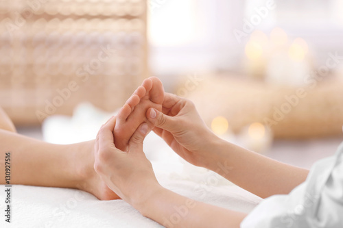 Foot massage in spa salon, closeup photo