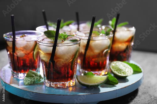 Glasses of cocktail with ice on dark background