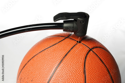 Air pump fills an orange basketball © knowlesgallery