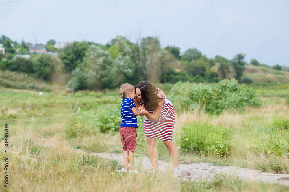 Pregnant woman kissing her child Pregnant woman kissing her child