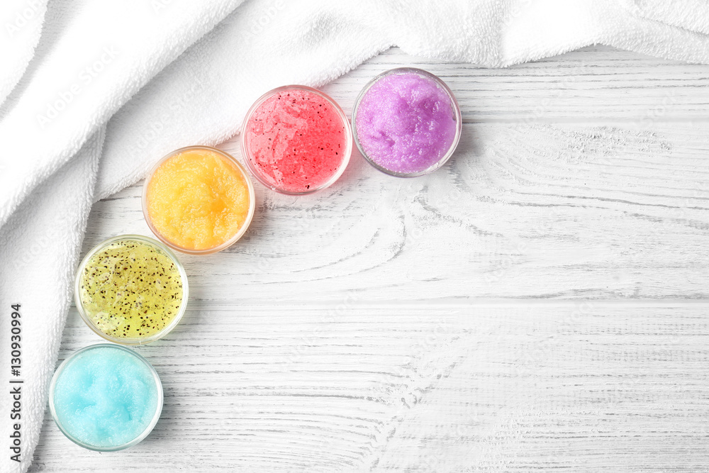 Body scrubs on wooden background