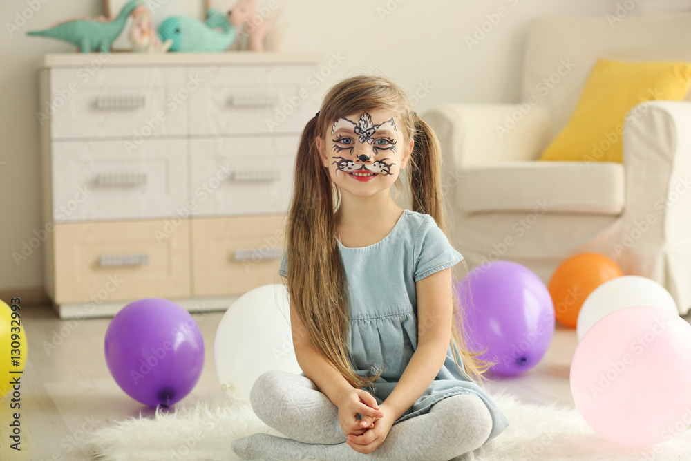 Fototapeta premium Funny girl with face painting sitting on floor in her room